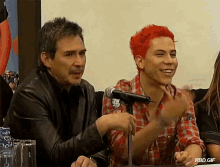 a man and a boy are sitting in front of a microphone with rbd.gif written on the bottom right