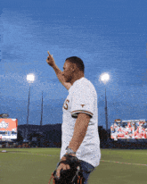a man wearing a texas jersey is standing on a baseball field