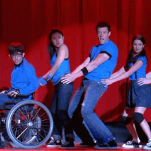 a man in a wheelchair is being pulled by two other people on a stage