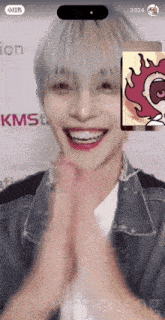 a man is smiling and clapping in front of a kmst logo