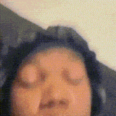 a blurry picture of a person 's face with their eyes closed .