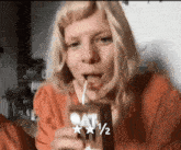 a woman is drinking oat milk through a straw and there are two stars next to her