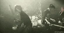 a group of people are playing instruments on a stage in a band .