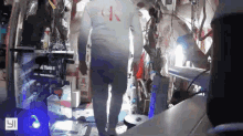 a man wearing a white calvin klein shirt walks through a room