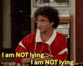 a man in a red jacket is sitting at a table and says i am not lying