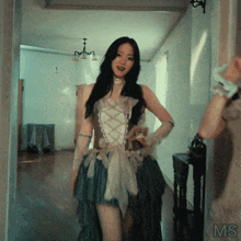 a woman in a dress is standing in a hallway with the word ms on the bottom