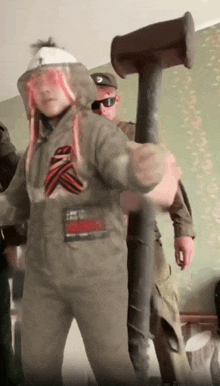 a man in a military uniform is holding a large hammer in his hand