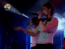 a woman singing into a microphone on stage