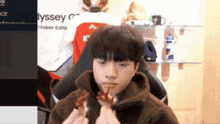 a man is eating a piece of food in front of a sign that says " dyssey "