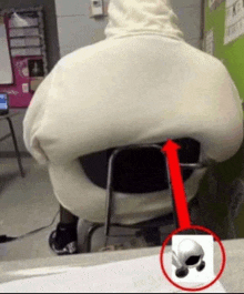 a person in a white hoodie is sitting in a chair with a red arrow pointing to the back of the chair