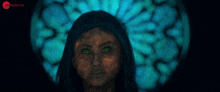 a woman with green eyes is standing in front of a colorful background that says xtra music co.