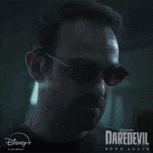 a poster for daredevil born again shows a man wearing red glasses