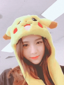 a woman wearing a pikachu hat is smiling for the camera