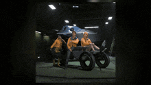 a group of people in orange jackets are standing in a dark room