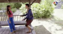 a man and a woman are standing next to each other on a porch .