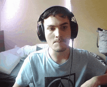 a man wearing headphones and a blue shirt with a circle on it