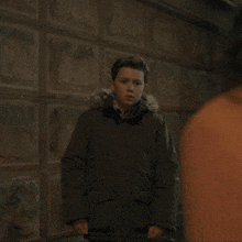 a young boy in a parka with a fur hood