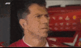 a man wearing ear buds and a headset is looking at the camera .