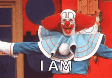 a clown in a blue and white outfit is standing in front of a red wall .