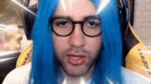 a man with blue hair and glasses is wearing a blue wig and headphones .