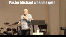 a man stands in front of a podium with the words pastor michael when he gets above him