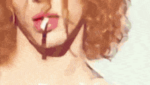 a close up of a woman 's face with red hair and lipstick on her lips .