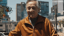 an older man wearing an orange jacket with the hashtag #karatekidmovie on the bottom