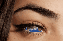 a close up of a woman 's eye with a wave painted on it