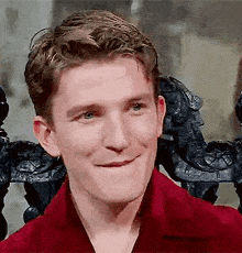a close up of a man in a red shirt making a funny face .
