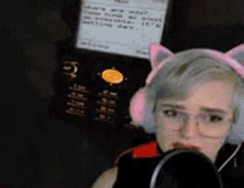 a woman wearing headphones and a cat ear headband is talking into a microphone
