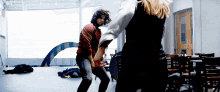 a man in a red shirt is dancing with a woman in a black dress
