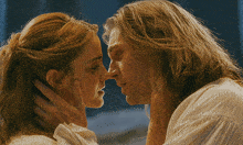a man and a woman are touching their faces