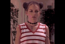 a girl with purple hair is wearing a choker and a striped shirt .