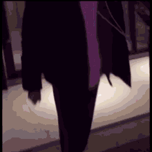 a person in a purple coat is walking down a staircase