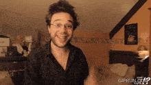 a man with glasses is smiling in front of a wall that has the word treat on it