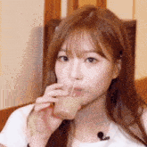 a close up of a woman drinking from a glass