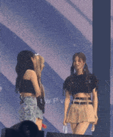 two girls are standing on a stage with the word twp visible