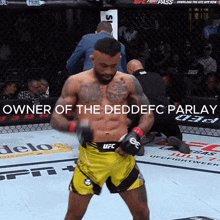 a man in a yellow ufc shorts stands in a boxing ring