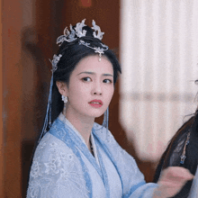 a woman wearing a blue and white dress and a tiara