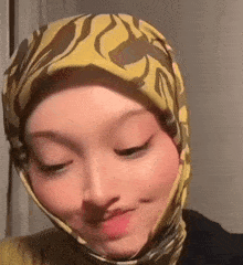 a close up of a woman wearing a yellow scarf on her head