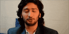 a man with his eyes closed is wearing a suit and white shirt