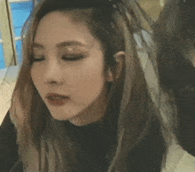 a close up of a girl with her eyes closed