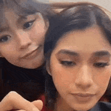 two women are standing next to each other and making funny faces .