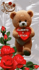 a teddy bear holding a red heart with the words alberto y leticia written on it
