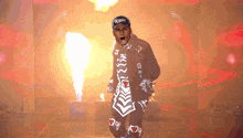 a man wearing a hat that says xtreme is walking through a tunnel of flames