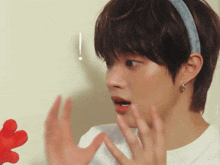 a young man wearing a headband looks surprised