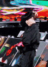 a man in a black jacket is dancing on stage