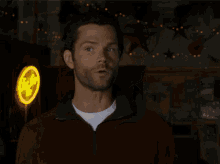 a man in a brown jacket stands in front of a neon sign that says ' texas ' on it