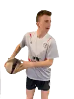 a young man wearing a shirt that says ' rugby ' on it is holding a rugby ball
