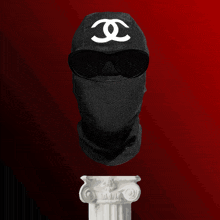 a person wearing a black mask with a white chanel logo